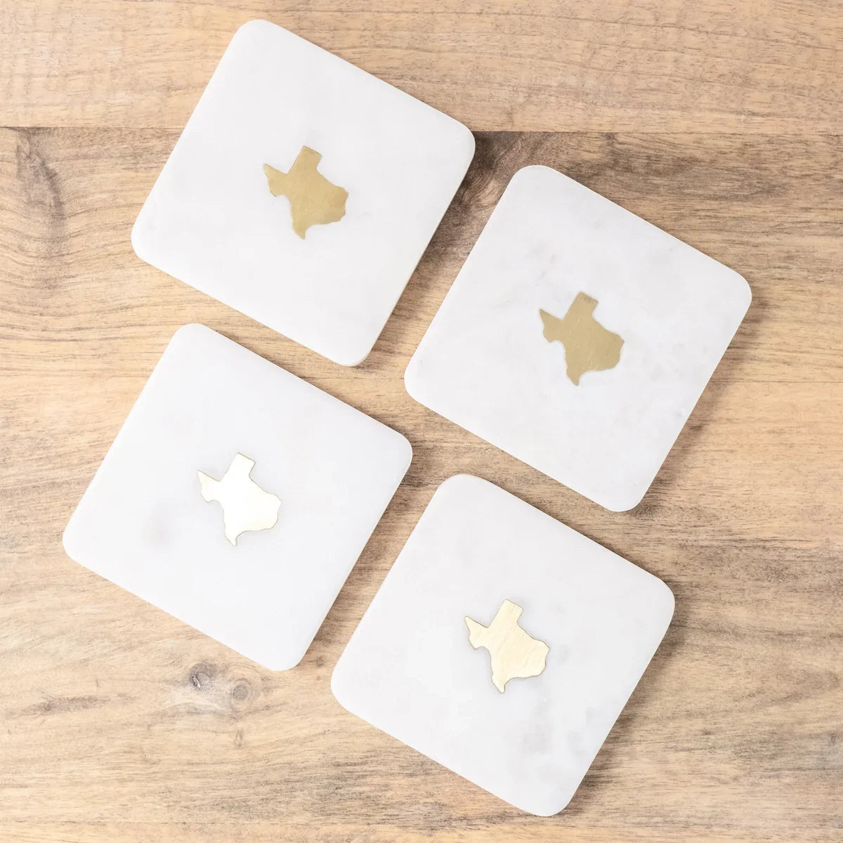 Texas Marble Coasters Set of 4 featuring white marble with brass accents and a gold Texas emblem.