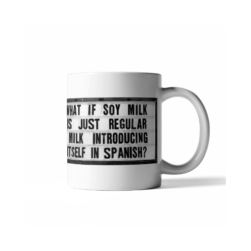 White ceramic coffee mug with the humorous quote "What If Soy Milk Is Just Regular Milk Introducing Itself in Spanish?" in bold black text.