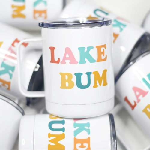 Stainless steel travel cup with the phrase "Lake Bum" printed on both sides, ideal for lakeside relaxation.